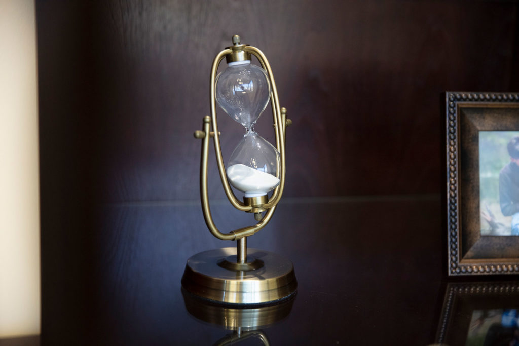 picture of hourglass in brass stand in an office setting