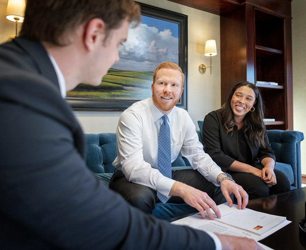 a FCS financial advisor discussing wealth management with two clients